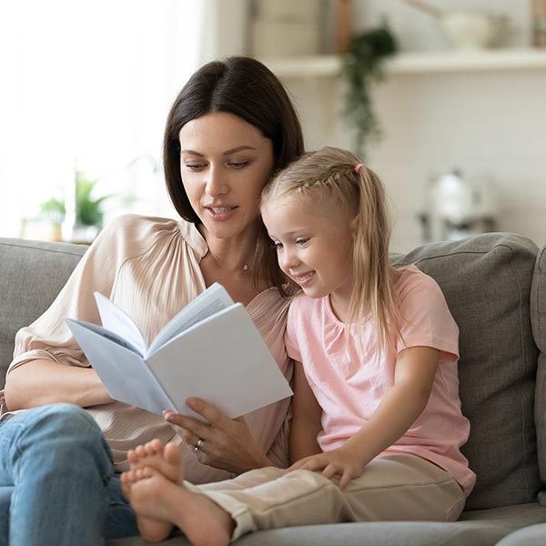 young woman reading to a young girl