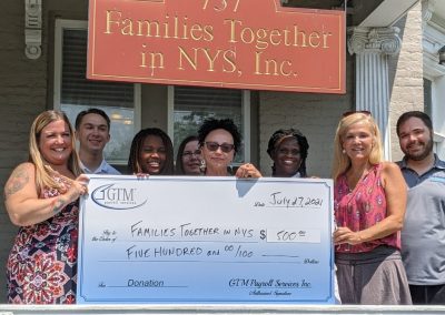 Members of Families Together and a large check