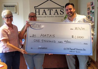 Homeless and Travelers Aid Society holding a large check