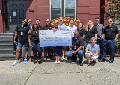 Hospitality House members holding a large check