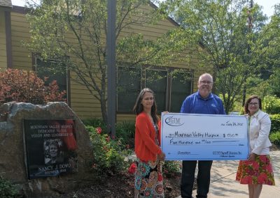 Mountain Valley Hospice holding a large check